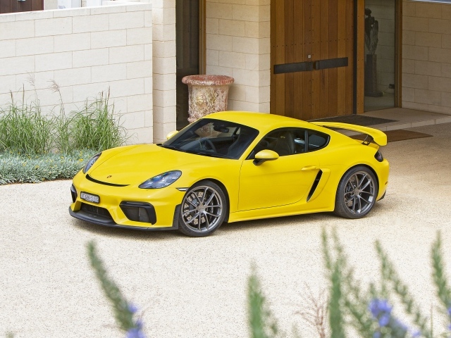 Желтый автомобиль Porsche 718 Cayman GT4,  2020 года