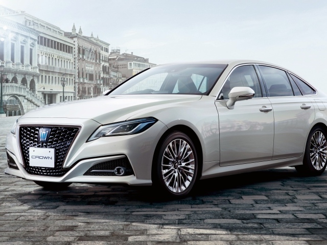 Стильный автомобиль Toyota Crown S, 2020 года на фоне здания