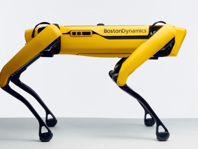 Желтый четвероногий робот Спот на белом фоне