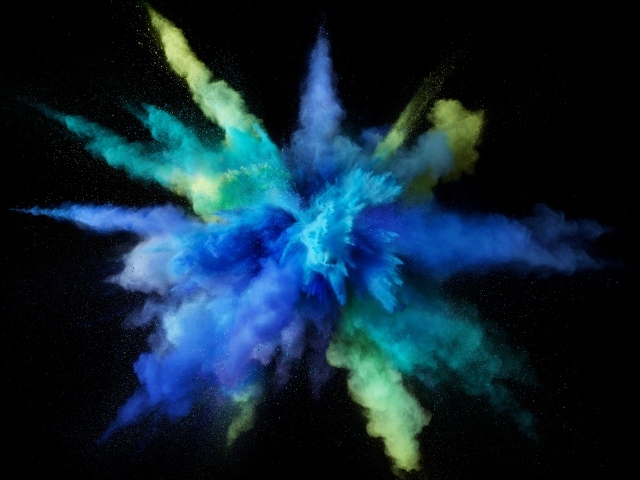 Взрыв сине-желтой краски на черном фоне