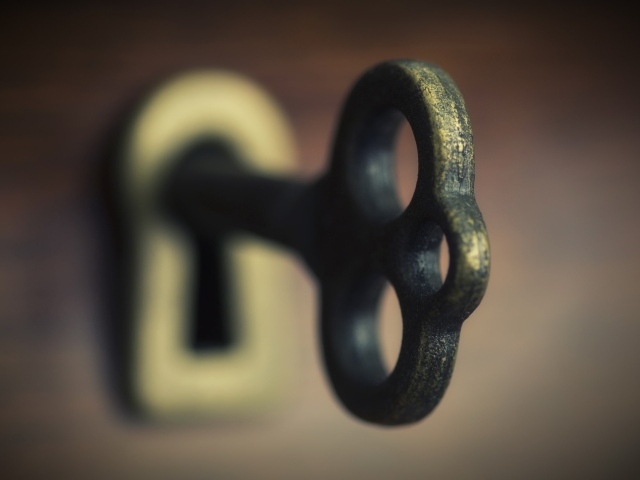 Большой железный ключ в замочной скважине 