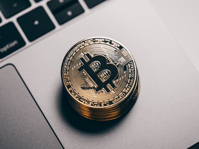 Монеты биткоин лежат на ноутбуке