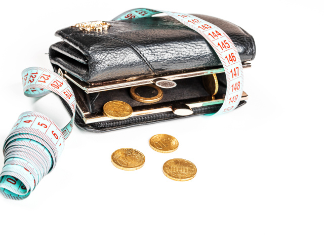 Черный кожаный кошелек с монетами и сантиметром на белом фоне