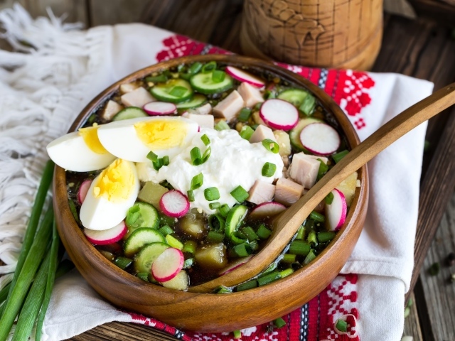 Холодная окрошка в деревянной миске на столе 
