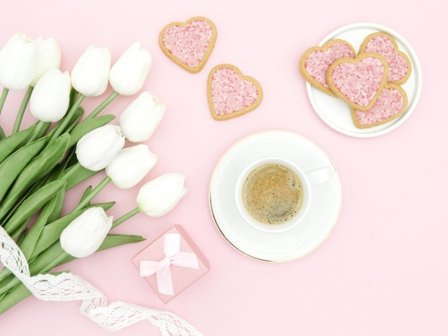 Чашка кофе с печеньем на столе с букетом белых тюльпанов