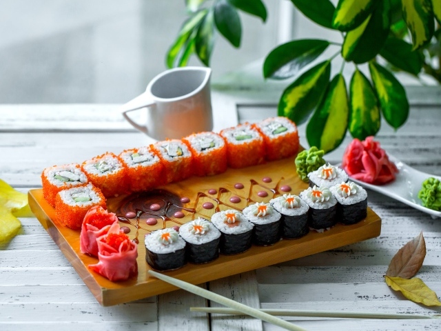 Вкусные суши и роллы на столе с имбирем