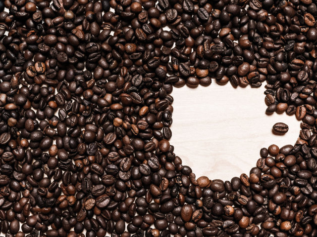 Рисунок чашки из кофейных зерен на столе