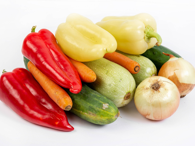 Свежие кабачки, огурцы, морковь, перец и лук на белом фоне