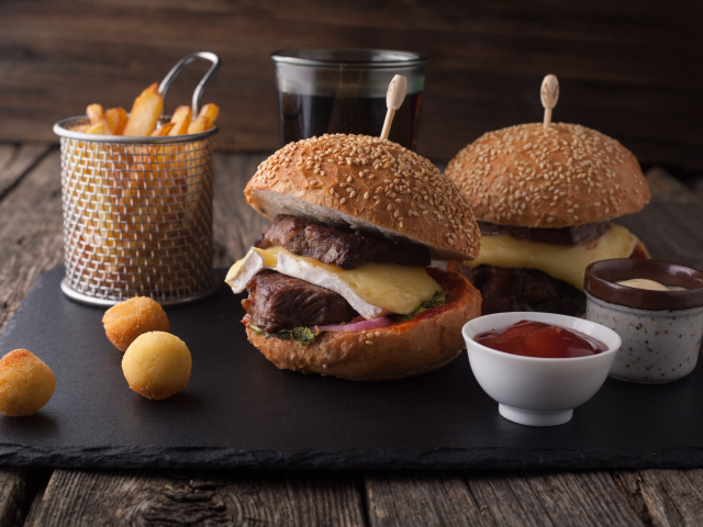Гамбургеры с мясо на столе с картофелем фри и соусом