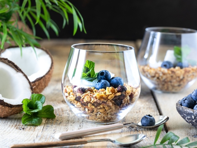 Мюсли с ягодами черники на столе с кокосом