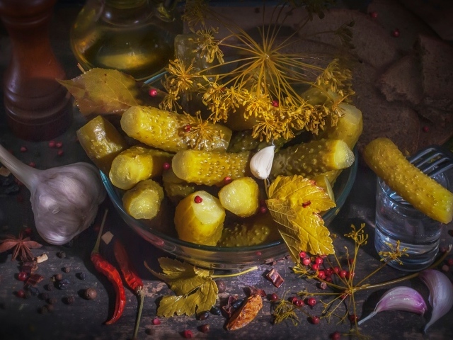 Маринованные огурцы на столе со специями и чесноком