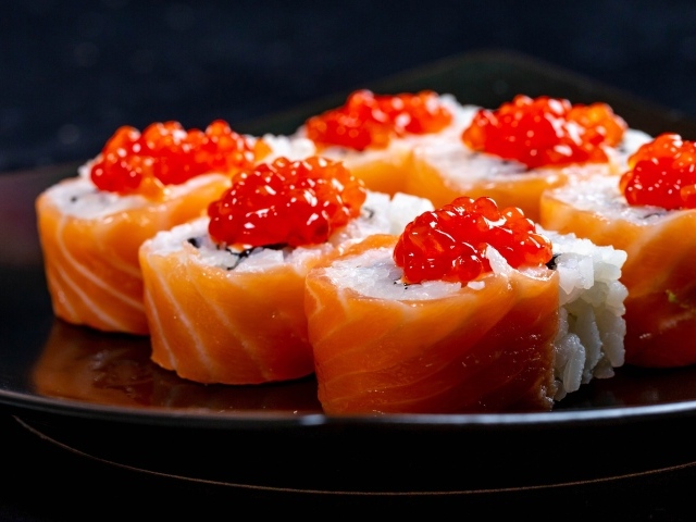 Роллы с красной рыбой и икрой на тарелке