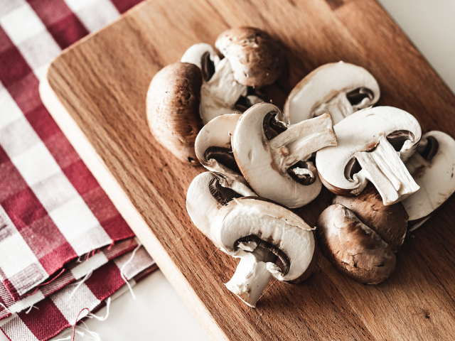 Нарезанные шампиньоны на разделочной доске