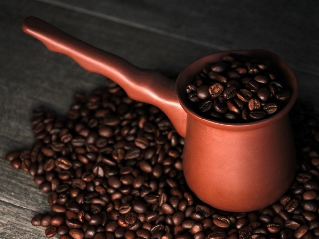 Турка с кофейными зернами на столе 