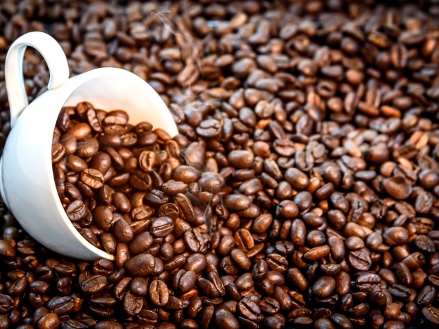 Белая чашка с жареными кофейными зернами