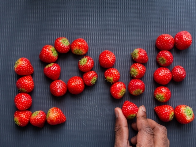 Надпись LOVE выложена из ягод спелой клубники 