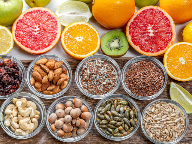 Орехи, зерна и цитрусовые фрукты на столе
