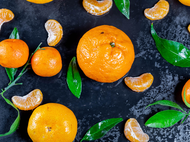 Оранжевые мандарины на мокрой поверхности 