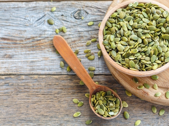 Тыквенные семечки в деревянной посуде на столе