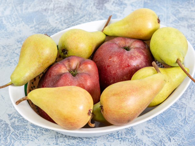 Красные яблок и груши на тарелке на столе