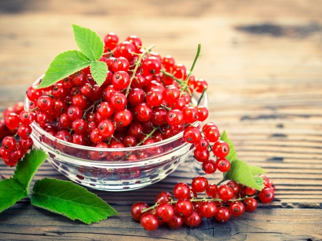 Красная смородина в стеклянной миске на столе 