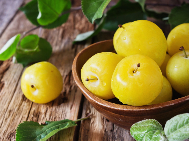 Вкусные желтые сливы в миске на столе