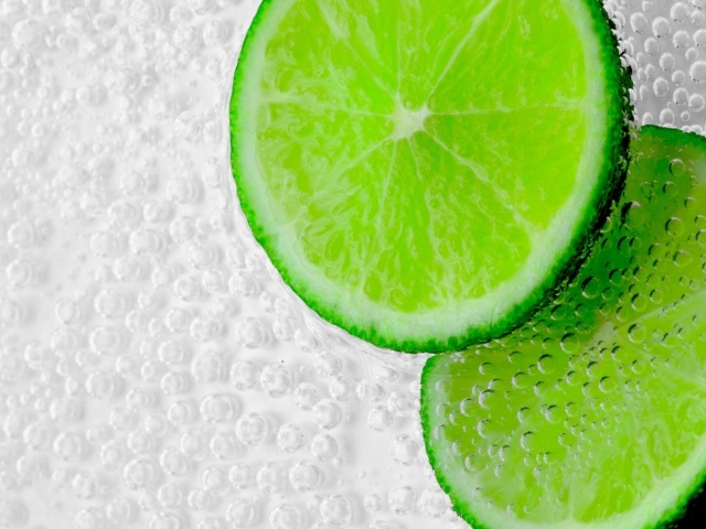 Два куска лайма в пузырях в воде 