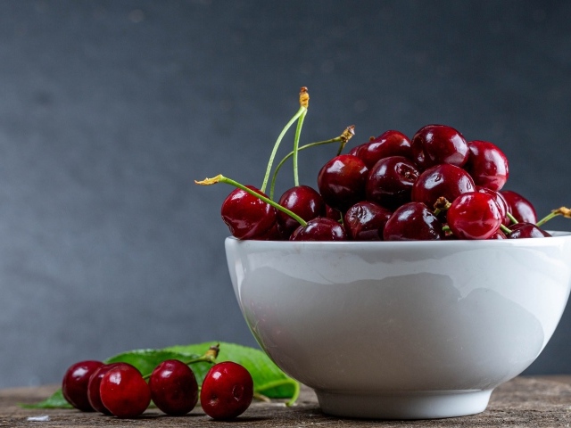 Белая фарфоровая тарелка с красной спелой черешней 