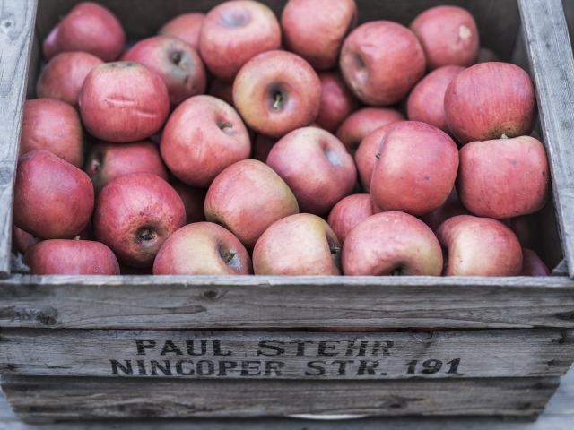 Деревянный ящик с красными спелыми яблоками