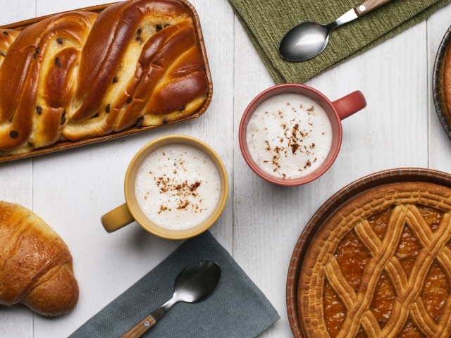 Свежая выпечка и две кружки молока на столе