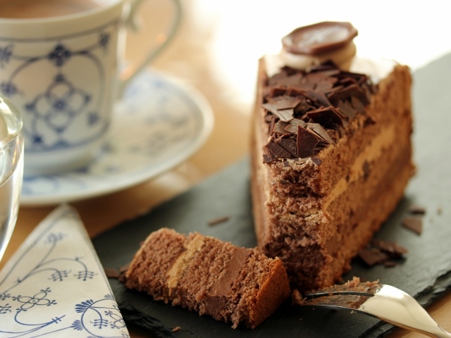 Кусок торта с шоколадом на столе с кофе