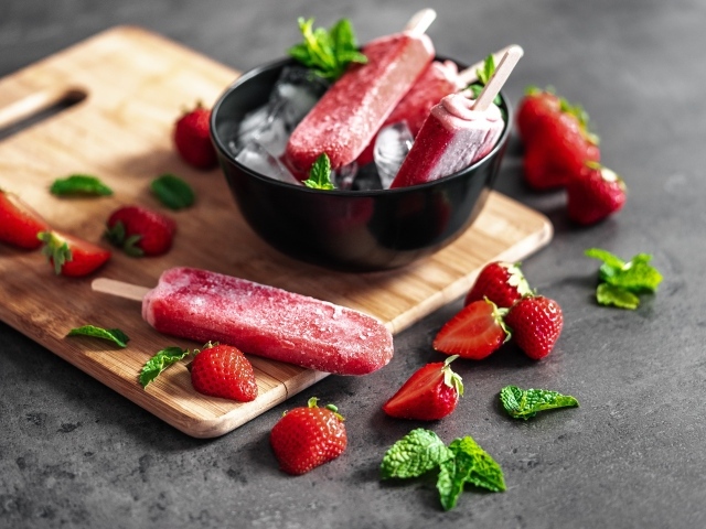 Ягодное мороженое с клубникой и мятой на столе 