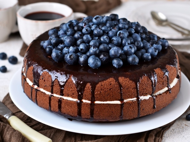 Шоколадный пирог с ягодами черники  на столе с кофе