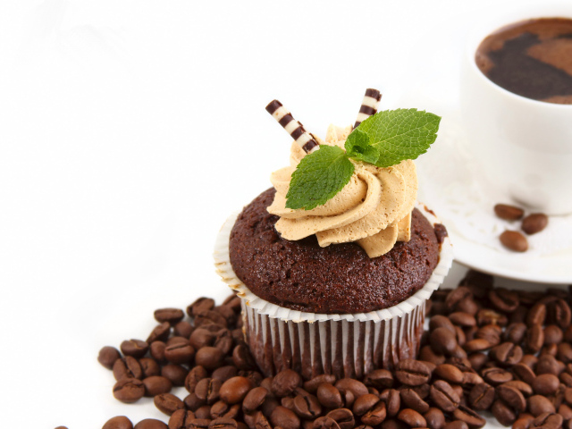 Шоколадный кекс с кремом на столе кофе и кофейными зернами