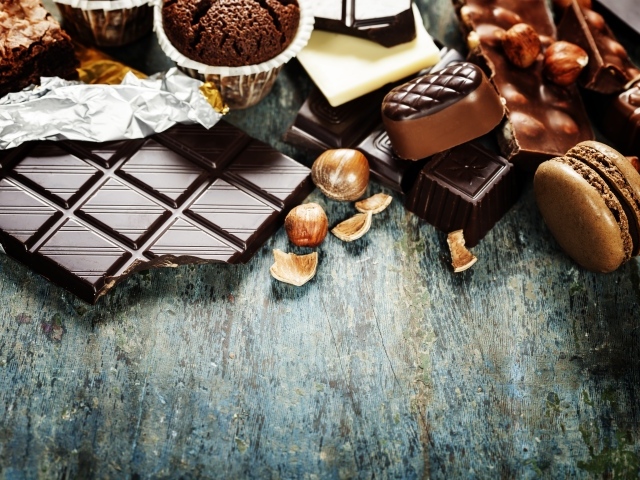 Шоколад на столе с орехами, кексами и конфетами 