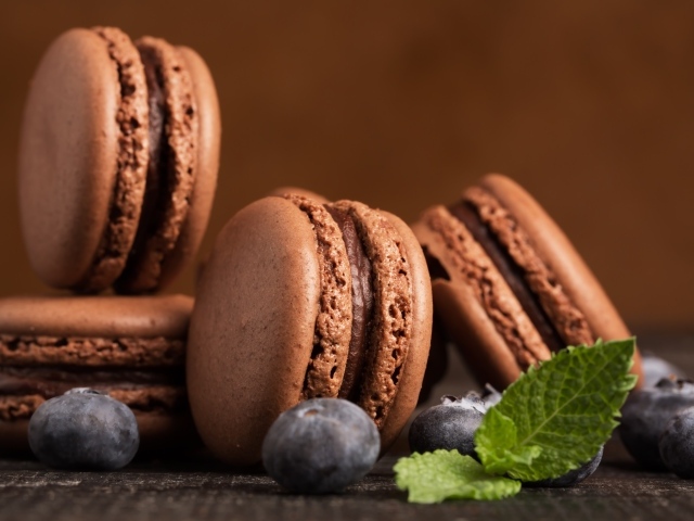 Шоколадный десерт макарон на столе с черникой 
