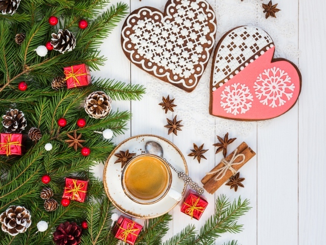 Печенье в форме сердца на столе с чашкой кофе и еловой веткой