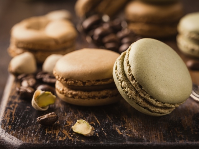 Десерт макарун на столе с кофейными зернами