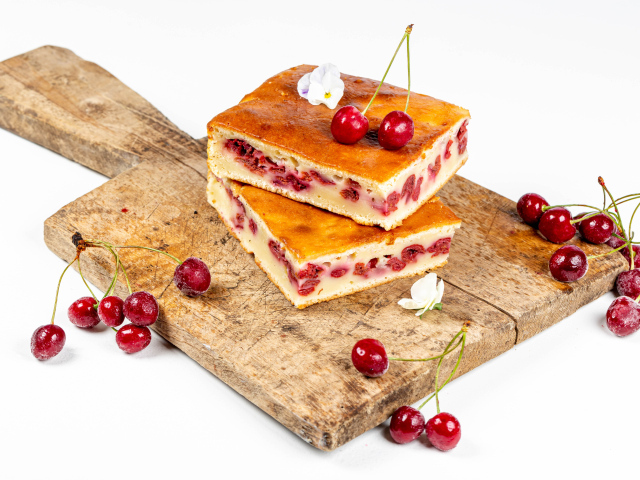 Пирог с вишнями на доске на белом фоне