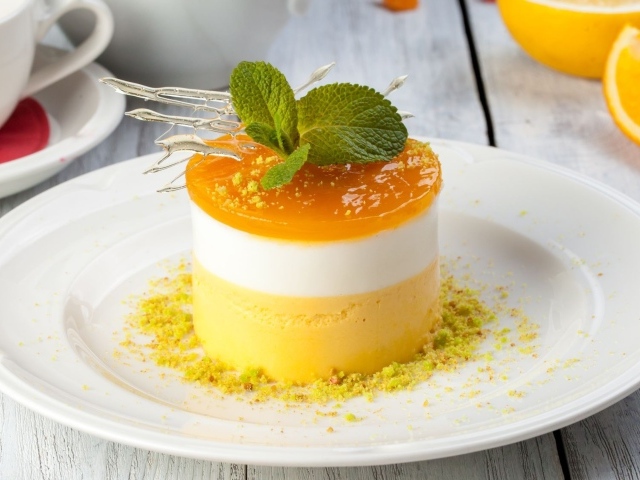 Вкусный десерт с мятой и фисташками на белой тарелке 