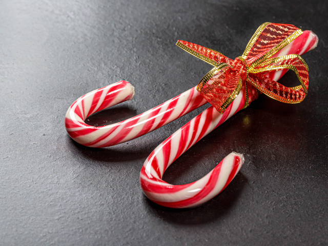 Два леденца перевязаны бантом на сером столе