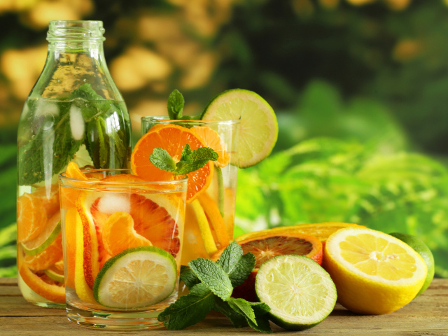 Холодный лимонад на столе с цитрусовыми