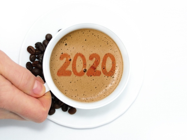 Чашка кофе в руке на белом столе с зернами