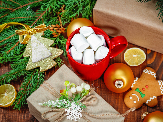 Чашка с маршмеллоу на столе с подарком, печеньем и еловой веткой