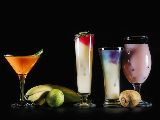 Вкусные тропические коктейли на черном фоне с фруктами