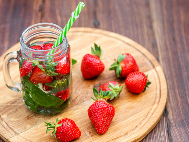 Напиток  в банке с ягодами клубники и трубочкой