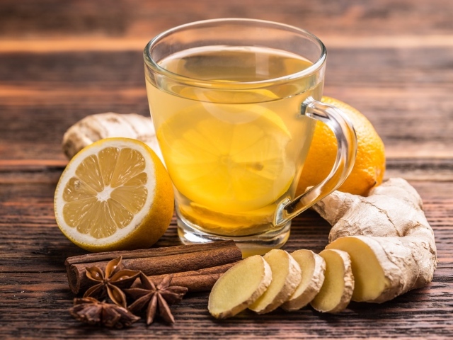 Стеклянная чашка чая на столе с лимоном, имбирем и специями