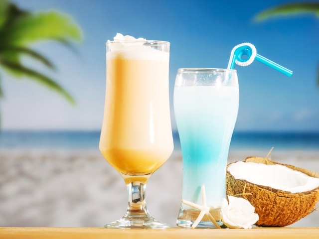 Два коктейля с кокосом на столе на тропическом пляже