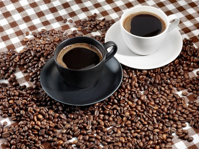 Две чашки ароматного кофе на скатерти с зернами