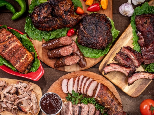 Вкусные запеченные мясные продукты на столе с овощами 